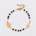 Detail of gold-plated stainless steel cross bracelet with black beads and religious medal - Gold