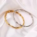 Bamboo style gold and silver stainless steel open bracelets on white silk background - Steel