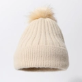 Close-up of beige ribbed knit beanie with a fluffy faux fur pompom and soft thick texture - Beige
