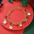 Detailed view of Christmas charm bracelet with Santa and Reindeer pendants on red stand - D1241 (Gold Thick Chain Reindeer)