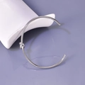 Detalle de brazalete abierto plateado con nudo de acero inoxidable pulido para mujer - Color Acero