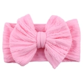 Detailed view of pink knitted baby headband featuring a large textured bow design - Pink