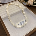 Detail of elegant white pearl necklace with golden clasp on beige jewelry tray - 9# Necklace-White-10mm