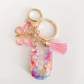 Pink resin letter U keychain with glitter butterfly pendant and silk tassel on gold ring - Letter U