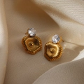 Dettaglio macro di orecchini a fiore placcati oro con zircone bianco su tessuto satinato - Design Zircone a Forma di Ventaglio