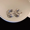 Macro view of triple-layered silver hoop earrings with clear reflection on mirror surface - Multi-layer Design (8#)