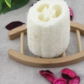 Natuurlijke luffaspons op een houten afdruprek met decoratieve bloemelementen - 13cm / 5 inch gebleekt loofah segment