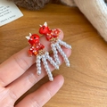 Detail of 18K gold plated red horse earrings with white pearl tassels on wood background - Red Horse Pearl Tassel Style / Silver Pin Red-White