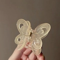 Macro shot of a transparent butterfly hair claw clip with visible metal spring detail - Jelly Yellow
