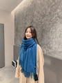 Elegant blue cashmere-feel wool scarf with fringe trim worn by a model in winter style - Dusty Blue