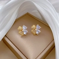 Close-up of gold heart-shaped clover earrings with sparkling cubic zirconia on silk - Gold Clover Stud Earrings (D528)