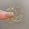 Detailed close-up of set of 4 gold hoop earrings in smooth and matte textured finishes - Triple Circle / Gold