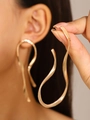 Irregular golden wave-shaped liquid metal earrings with a modern artistic design - Gold Wave Dangle