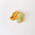 Detail of peanut-shaped pendant with golden metal shell and two green gemstones - Green Peanut*Gold