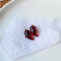 Dettaglio di ciondoli a fantasma in resina bordeaux traslucida con ganci dorati - Fantasma Rosso Vino