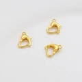 Detail-Nahaufnahme von drei 14k vergoldeten herzförmigen Karabinerverschlüssen für Schmuck - 18K Gold