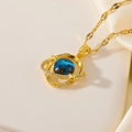 Elegante gouden planeetketting met blauwe nebulasfeer en fonkelende steentjes - Beringde Planeet / Goud