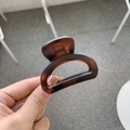 Detail of a brown tortoise shell hair claw clip with a glossy acetate resin finish - Matte Red Brown