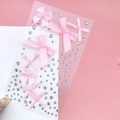 Detail of pink ribbon bow stickers and shimmering rhinestones on a clear adhesive sheet - BJA-638 (Pink Bow Tie)
