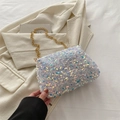Colorful sequin crossbody bag for women with a gold chain strap in a lifestyle setting - White