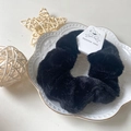 Soft black plush faux fur scrunchie hair tie with white bow tag in a white dish - Black