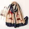 Detail of cotton linen scarf with horsebit patterns and red-green stripes beside a magazine - Beige Plaid (Red & Green Web) (SL2107-016)