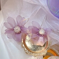 Dettaglio macro di orecchini a fiore in tulle viola con pistilli di cristallo su vassoio - Petali Viola