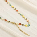 Detail of gold chain necklace with colorful enamel daisies on beige pleated fabric - Gold Five-Color Flower Necklace (KN233352-TK)