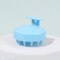 Light blue silicone scalp massager brush with ergonomic T-handle on display stand - Blue