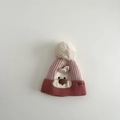 Dettaglio del cappello in maglia rosa per neonati con design a coniglio e pompon bianco - Cappello / Rosa
