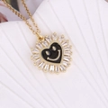 Close-up of golden heart pendant with black enamel smiley face and zircon border - Black