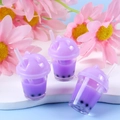 Three purple bubble tea cup keychains with black pearls and straws on floral background - Purple