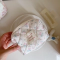 Close-up of pink floral quilted cotton cosmetic bag with chic fabric label detail - Light Blue & Pink Small Flowers