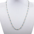 Golden bead chain necklace with sky blue turquoise accents on a jewelry display stand - Gold + Lake Blue
