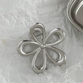 Macro view of silver floral hair claw clip with metallic mirror finish and spring detail - Large / Silver