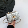 Silver quilted mini chain bag with gold twist lock shown in a hand-held view - Silver
