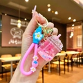 Détail d'un porte-clés bouteille de sable mouvant rose avec lanière marguerite - Coupe Iceberg Lumineuse Rose avec Fleurs Séchées