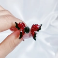 Dettaglio ravvicinato dell'anello a farfalla con smalto rosso e nero e gemma nera - Farfalla ala rossa in agata nera