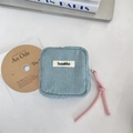 Close-up of blue corduroy cosmetic bag with pink rope zipper and woven logo detail - Light Blue Grey