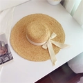 Natural raffia sun hat with wide frayed brim and cream ribbon on white background - Flat Top Bow Straw Hat