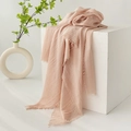 Elegant long pink linen blend scarf with fringe tassels on white pedestal stand - Nude Pink