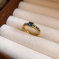 Dettaglio anello vintage oro con gemma blu quadrata e fascia con trama a catena - Stile Quadrato Oro / Oro Antico