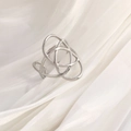 Macro shot of a vintage silver irregular knot ring on elegant white silk fabric - Silver Tone Celtic Knot