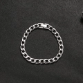 Détail du bracelet gourmette en acier titane argenté avec fermoir sur fond noir texturé - 8mm*17cm
