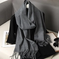 Dettaglio di una morbida sciarpa grigia effetto cashmere con frange su sfondo sobrio - Grigio
