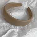 Detailed view of thick light brown headband with litchi texture faux leather surface - Light Camel