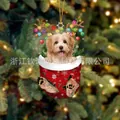 Weihnachts-Hundesocken-Anhänger mit Rentiergeweih an einem festlichen Baum - Goldpudel