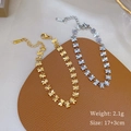 Détail de bracelets trèfle à quatre feuilles or et argent sur un support en cuir - Doré