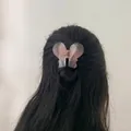 Detail of elegant pink translucent butterfly hair claw clip worn by a model in back view - Pink