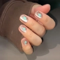 Close-up of nude press-on nails with mint green stars and shiny cat-eye effect finish - By1522 Meteor Chasing The Moon / Glue Type
